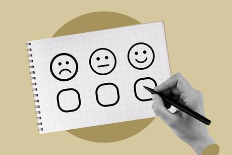 Hand filling in survey checking a happy face