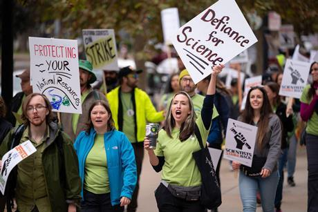 People on a protest march holding placards that read Defiance for Science and Scientists Strike Back