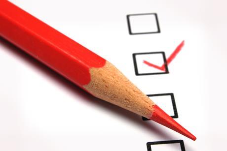 A red pencil with a tick box