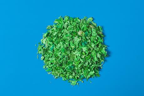 蓝色背景的绿色塑料回收聚合物部件