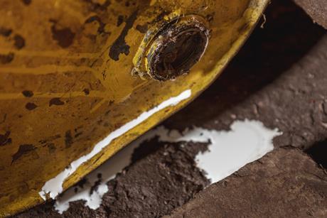 Liquid spills out of a rusty old barrel