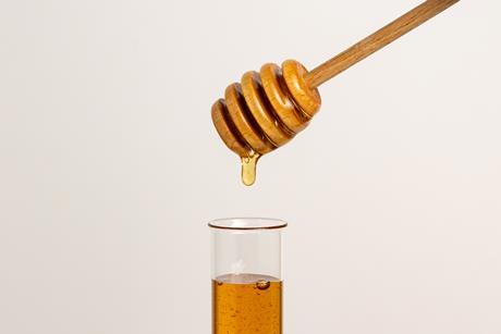Honey dripping into a test tube