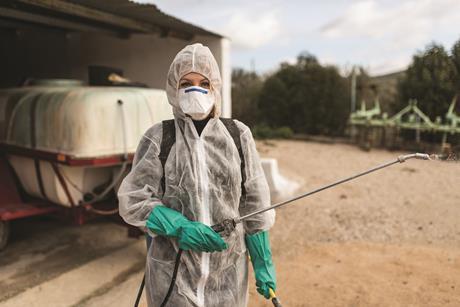 image shows female pesticide worker in PPE