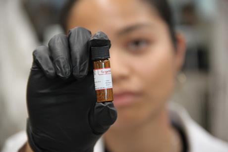 Denise Catacutan with a glass vial