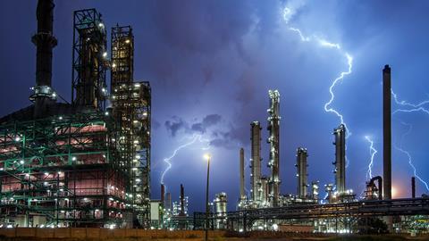 Lightning bolt on top of oil refinery
