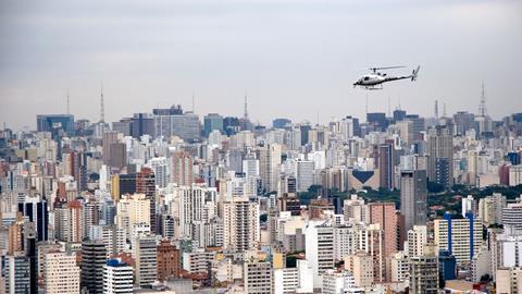 An image showing an aerial view of Sao Paulo and a helicopter in flight Brazil