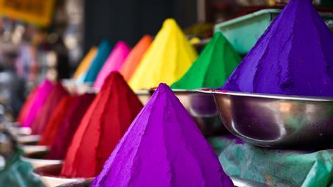 Piles of colored powders in an Indian market – holi colors