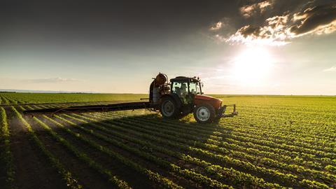 An image showing a tractor spraying crops