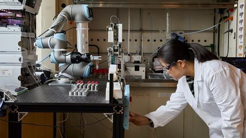 Scientist operating robotic arm in lab