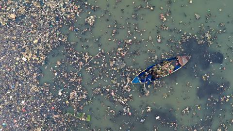 一艘船在一条污染严重的河中央的俯视图