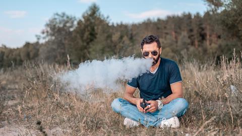 An image showing a man who is vaping