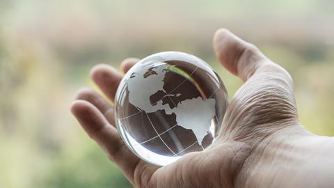 An image showing a hand holding a globe