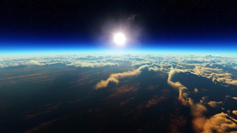 Sunrise over cloudy ocean from outer space