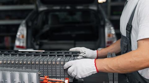 Serviceman repairs electric battery pack of hybrid car