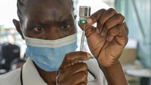 An image showing a health worker preparing a malaria vaccine to be administered