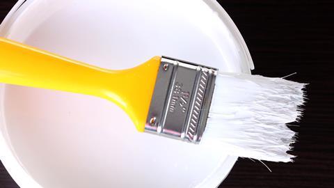 Paint brush on a tin of white paint
