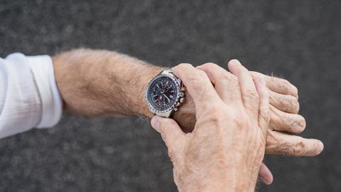 An image showing the hands of an old man looking at his watch