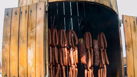 A photograph of meat in a smokehouse
