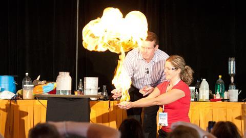 Steve Spangler igniting methane filled bubbles in the hands of a young teacher at Science in the Rockies 2011.