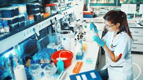Image of a female scientist sat down, working in a biological lab