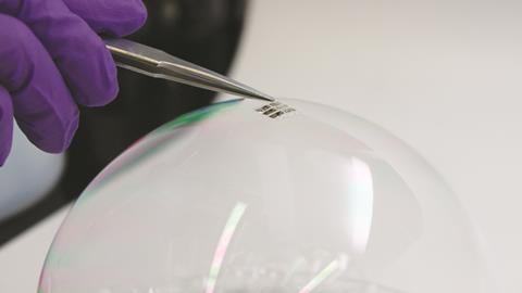 An ultra-lightweight solar cell is placed on the surface of an ordinary soap bubble