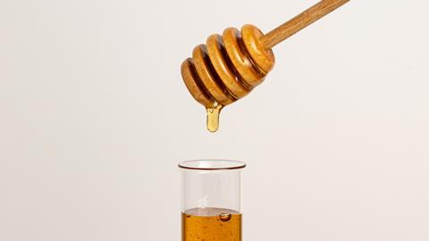 Honey dripping into a test tube