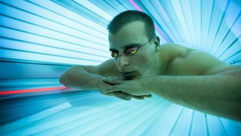 A man using a ultraviolet tanning bed
