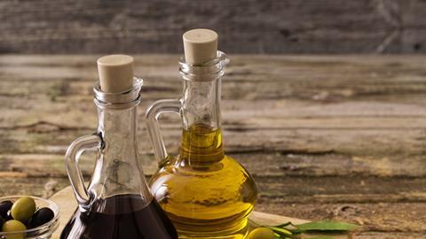 Bottles of olive oil and balsamic vinegar on a wooden table