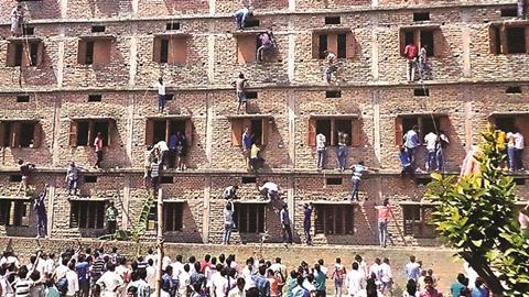 Relatives climbing exam building to help students pass exams, in Bihar, India, March 2015