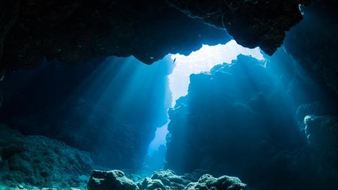 A photograph showing a ray of sunlight in an underwater cave