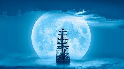 Sailing old ship in a storm sea with full moon stormy clouds in the background