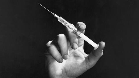 An image showing a hand holding a hypodermic needle