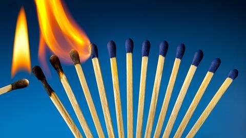 An image showing a row of closely positioned matches burning one by one in a domino effect fashion