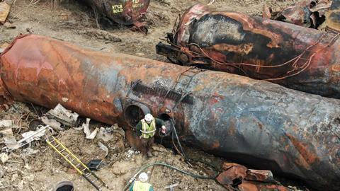 Aerial shot of two workers among some severely burnt rail tank cars