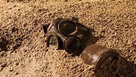 Vintage gas mask buried in the sand
