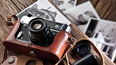 Vintage camera and photos on a wooden table