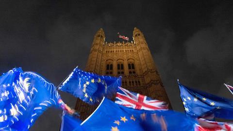 An image showing EU and Union flags fluttering in the breeze as Pro and anti-Brexit demonstrators protest outside of the Houses of Parliament in central London