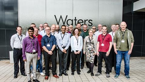 A group of Waters' employees pose outside one of their buildings