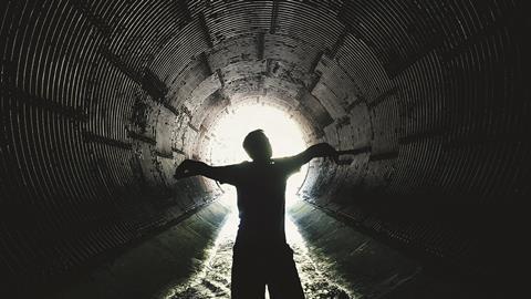 An image showing a silhouette of a man inside a sewer 