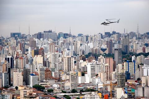 An image showing an aerial view of Sao Paulo and a helicopter in flight Brazil