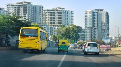 A photograph of a Bangalore street with tall buildings in the background
