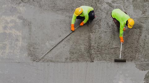 An image showing plasterer laying concrete cement with trowel