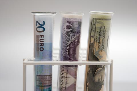 An image showing money inside test tubes