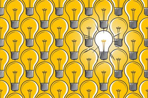 Lit light bulb in a sea of unlit light bulbs