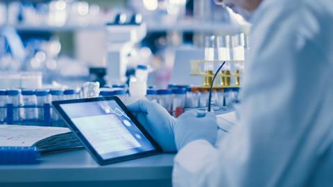 Image showing a lab worker holding a tablet in a lab