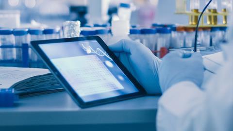 Image showing a lab worker holding a tablet in a lab