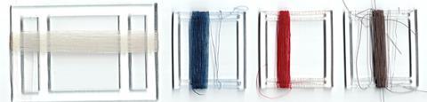 A photo of different coloured threads wound around plastic bobbins