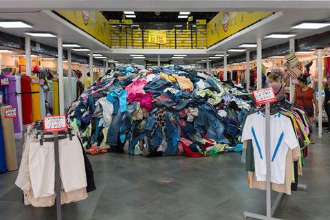 An image showing piles of clothes in a store