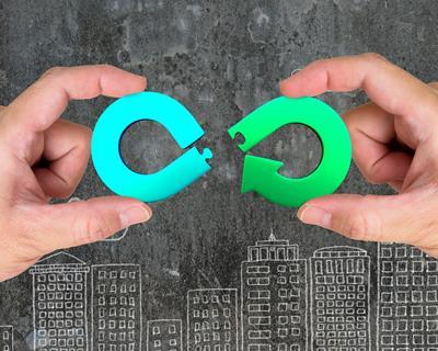Image shows two hands assembling a circular economy symbol