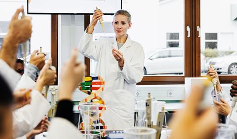 A chemistry teacher instructing university students in practical skills